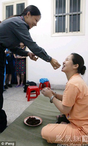 A female police officer feeds a lychee to condemned drug dealer Dai Donggu